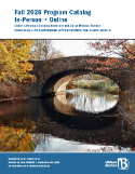 Stonebridge over a still river. It is fall and trees on either side of the bridge are in shades of yellow and orange.