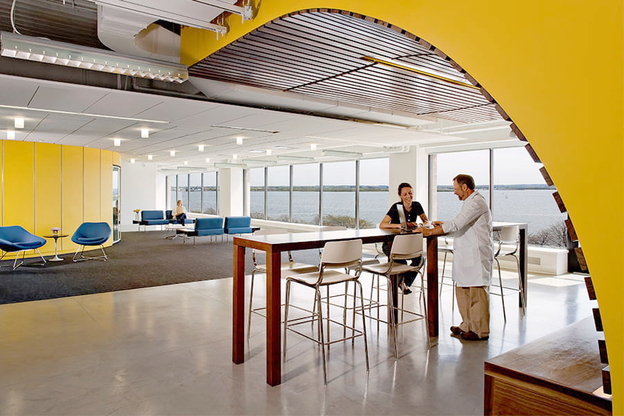 Two scientists stand inside the Venture Development Center lobby.