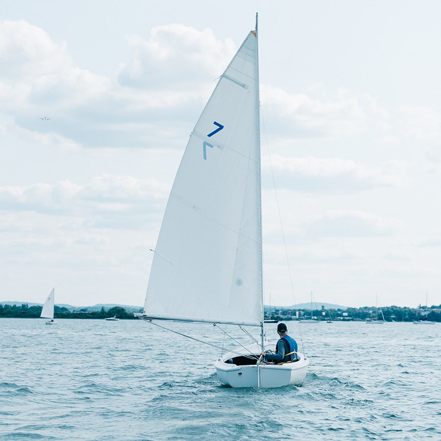 Man sailing in sail boat in water