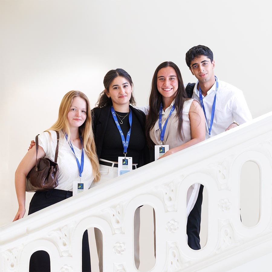 Four young adults stood on the stairs, smiling.