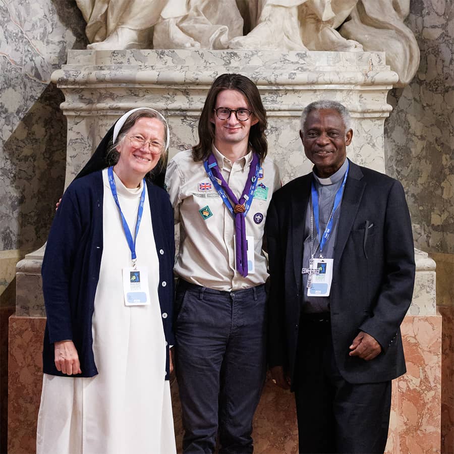 Group of three people standing in front of marble statue.