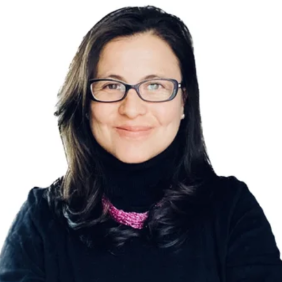Woman with long dark hair and glasses, wearing a black turtleneck with a pink scarf